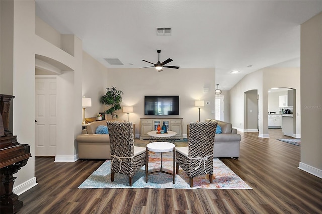 living area with a ceiling fan, visible vents, baseboards, arched walkways, and wood finished floors