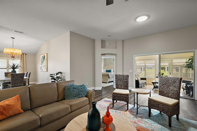 living room featuring arched walkways, dark wood-style flooring, visible vents, a notable chandelier, and lofted ceiling