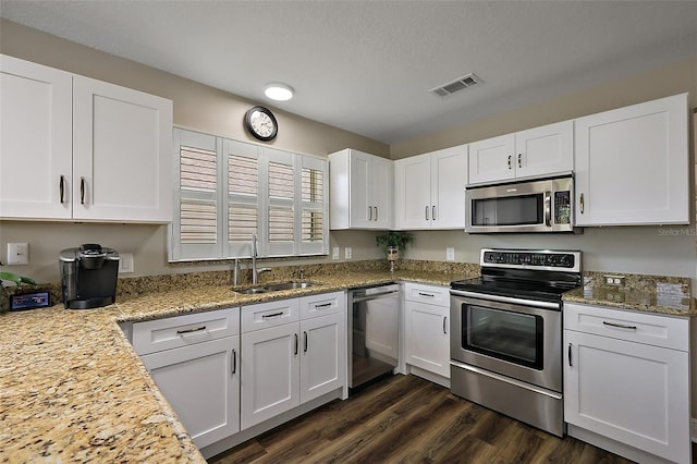 kitchen with white cabinetry, light stone countertops, appliances with stainless steel finishes, and a sink