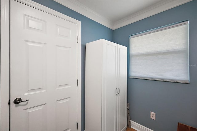 unfurnished bedroom featuring crown molding and baseboards