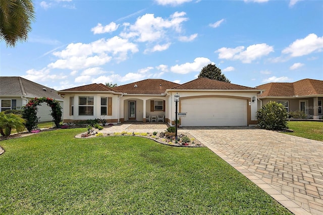 mediterranean / spanish-style house with stucco siding, driveway, a front yard, and a garage
