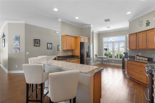 kitchen with visible vents, a peninsula, baseboards, a sink, and appliances with stainless steel finishes