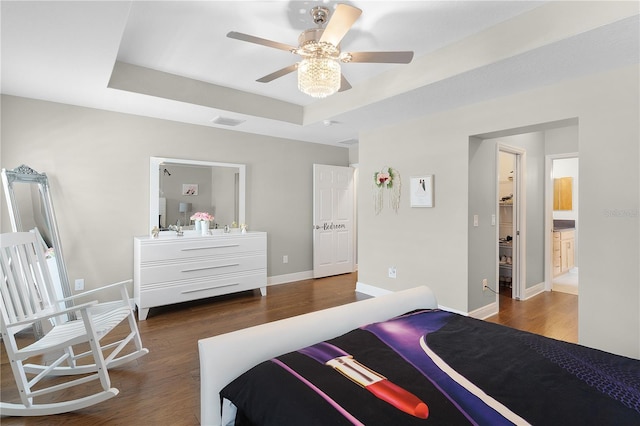 bedroom with visible vents, baseboards, ceiling fan, a raised ceiling, and dark wood finished floors