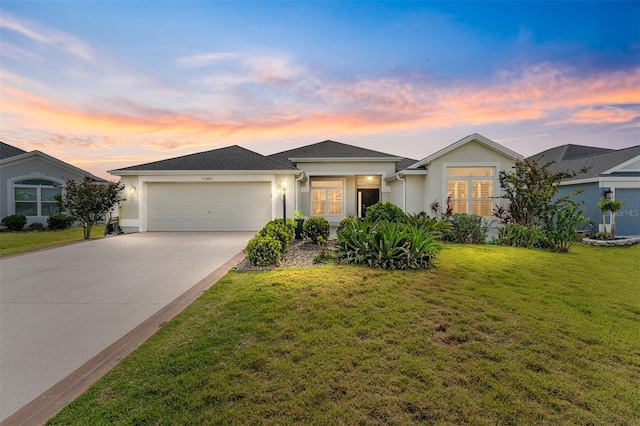 ranch-style home with concrete driveway, stucco siding, an attached garage, and a front yard