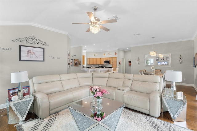 living area with a ceiling fan, visible vents, crown molding, wood finished floors, and baseboards