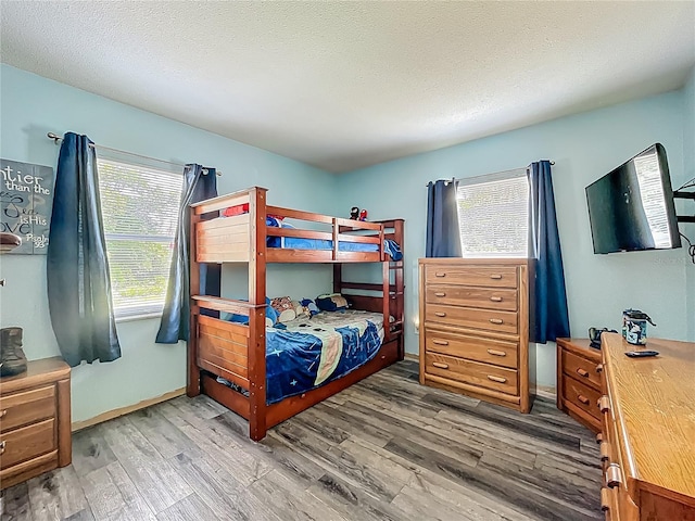 1001 N Lakeshore Blvd, Howey In The Hills, FL 34737 - bedroom with a textured ceiling, baseboards, multiple windows, and wood finished floors