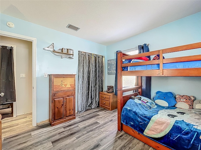 1001 N Lakeshore Blvd, Howey In The Hills, FL 34737 - bedroom featuring a textured ceiling, visible vents, and wood finished floors