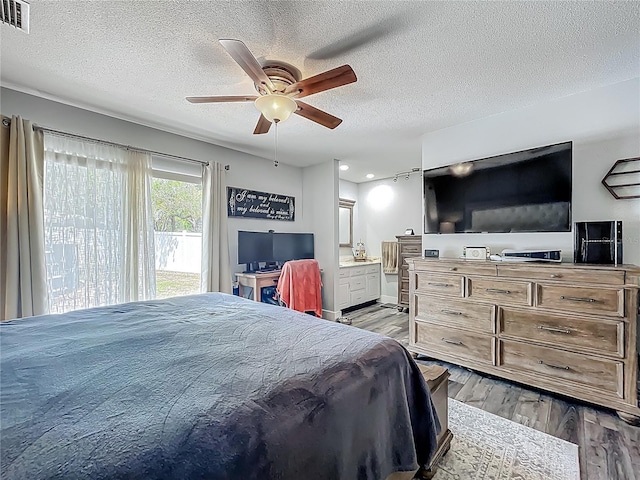 1001 N Lakeshore Blvd, Howey In The Hills, FL 34737 - bedroom with ensuite bath, a textured ceiling, visible vents, and wood finished floors