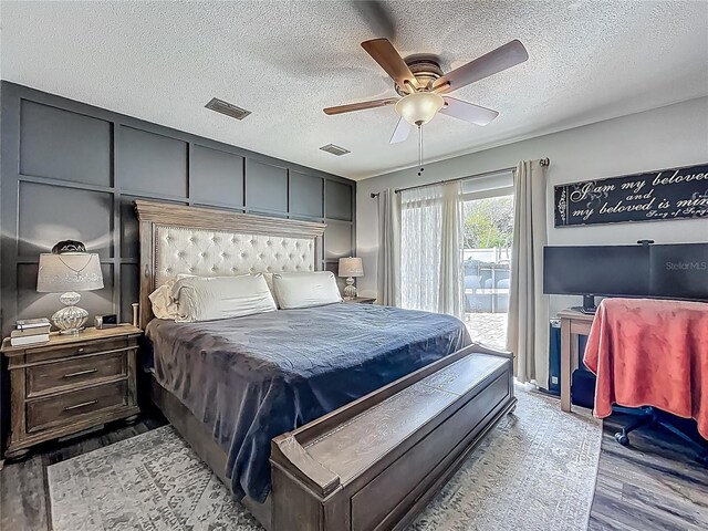 1001 N Lakeshore Blvd, Howey In The Hills, FL 34737 - bedroom with wood finished floors, visible vents, access to outside, and a textured ceiling