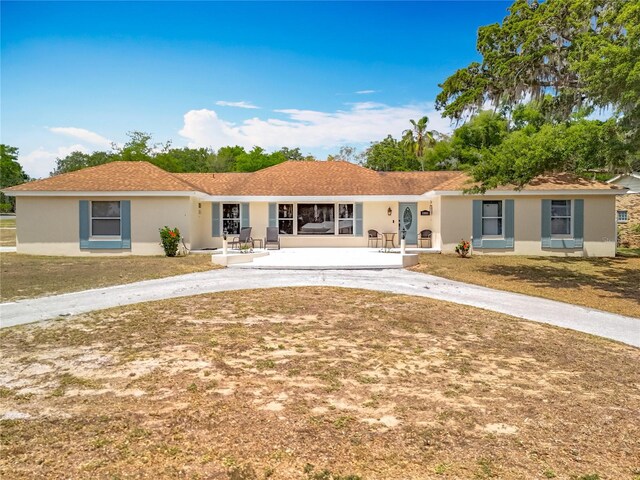 1001 N Lakeshore Blvd, Howey In The Hills, FL 34737 - single story home with covered porch, stucco siding, and curved driveway