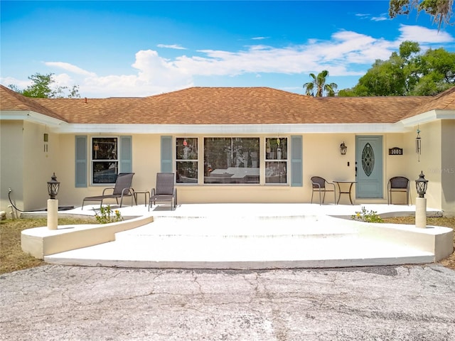 1001 N Lakeshore Blvd, Howey In The Hills, FL 34737 - rear view of property with covered porch, stucco siding, and roof with shingles