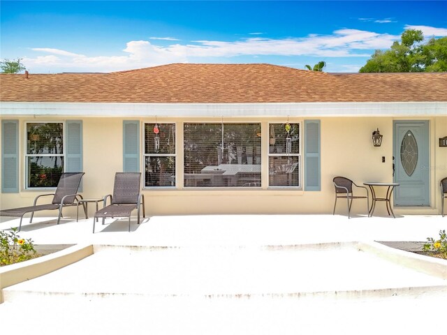1001 N Lakeshore Blvd, Howey In The Hills, FL 34737 - rear view of house with stucco siding, roof with shingles, and a patio area