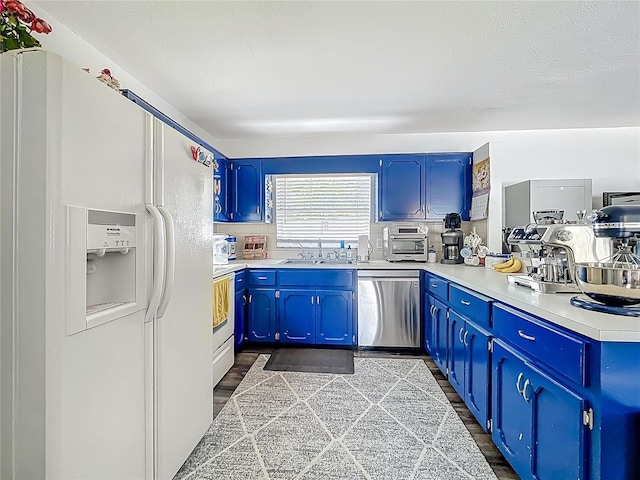 1001 N Lakeshore Blvd, Howey In The Hills, FL 34737 - kitchen featuring blue cabinets, white appliances, light countertops, and dark wood-style floors