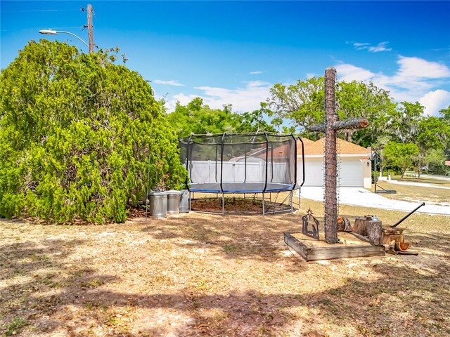 1001 N Lakeshore Blvd, Howey In The Hills, FL 34737 - view of yard featuring concrete driveway and a trampoline