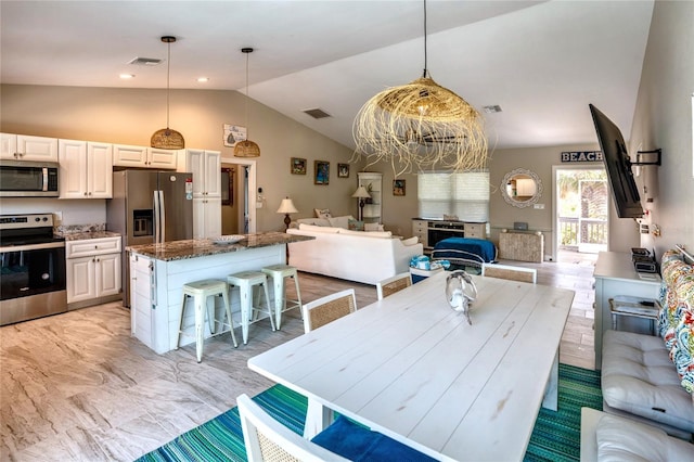 interior space featuring a kitchen breakfast bar, visible vents, stainless steel appliances, a kitchen island, and open floor plan