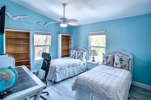 bedroom with baseboards, ceiling fan, and multiple windows