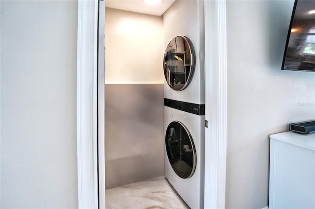 washroom featuring stacked washer and clothes dryer and laundry area