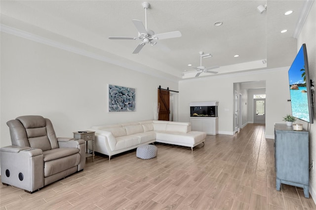 living area with recessed lighting, a barn door, ceiling fan, light wood-type flooring, and crown molding