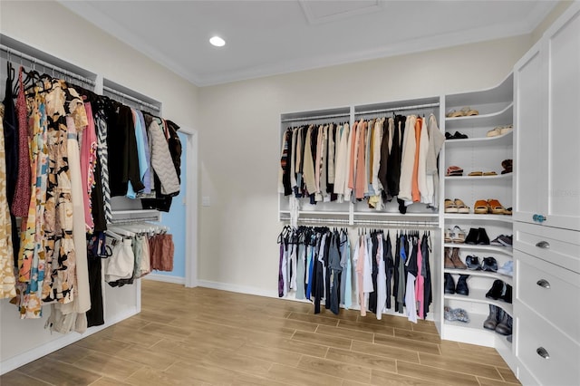 walk in closet with attic access and wood finished floors
