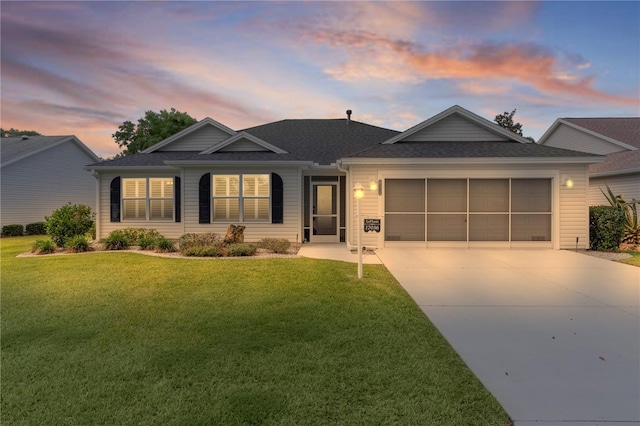 ranch-style home with an attached garage, driveway, roof with shingles, and a front lawn
