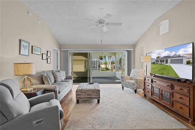 living area featuring a textured ceiling, ceiling fan, wood finished floors, and high vaulted ceiling
