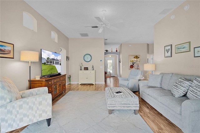 living room featuring a ceiling fan, visible vents, and light wood-type flooring