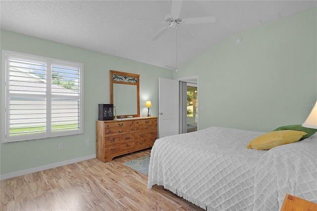 bedroom with ceiling fan, vaulted ceiling, baseboards, and light wood-type flooring