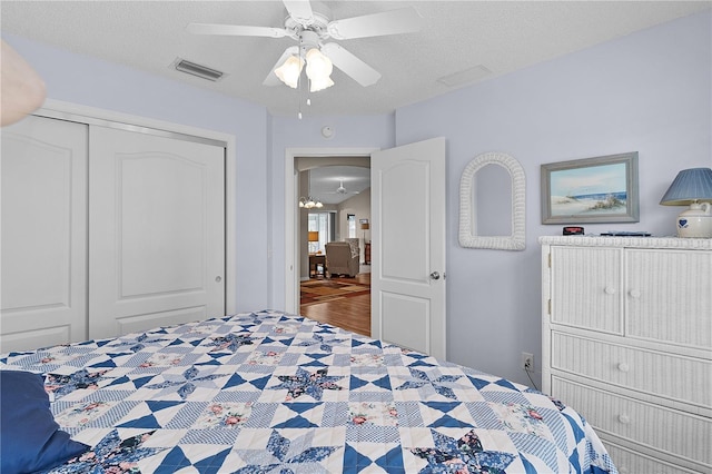 bedroom featuring visible vents, a ceiling fan, a textured ceiling, and a closet