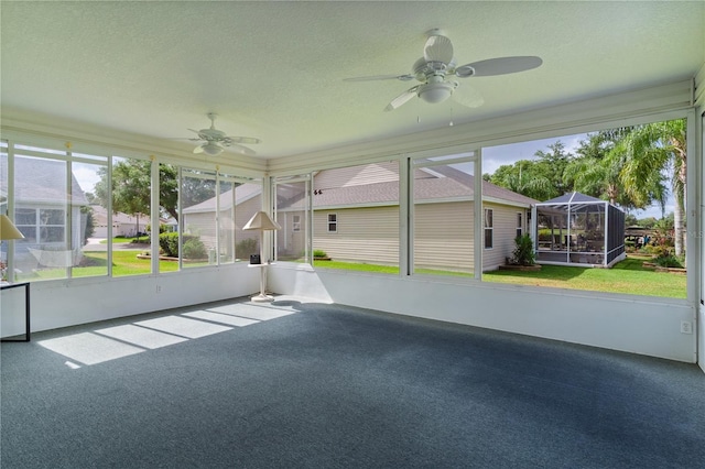 unfurnished sunroom featuring ceiling fan