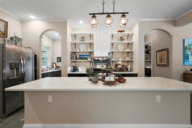 6905 Clayton St, Mount Dora, FL 32757 - kitchen with stainless steel fridge with ice dispenser, arched walkways, open shelves, a center island, and ornamental molding