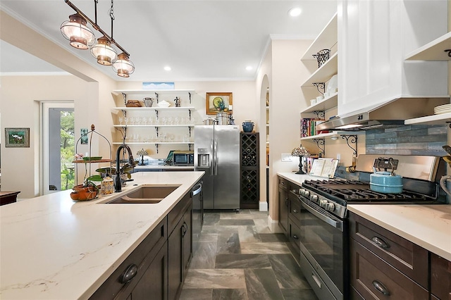 6905 Clayton St, Mount Dora, FL 32757 - kitchen with open shelves, stainless steel appliances, a sink, arched walkways, and ornamental molding