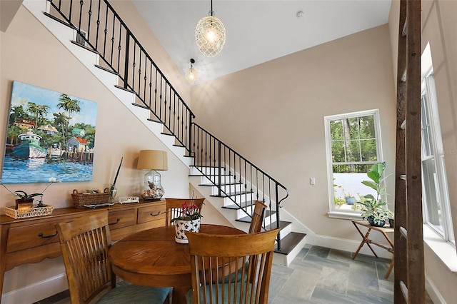 6905 Clayton St, Mount Dora, FL 32757 - dining room with stairs, stone tile floors, a towering ceiling, and baseboards