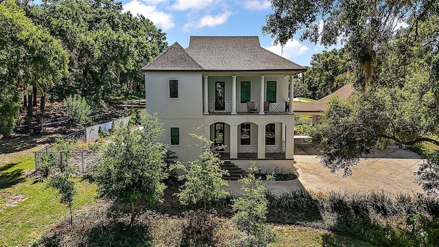 6905 Clayton St, Mount Dora, FL 32757 - view of front of home featuring a balcony, covered porch, stucco siding, fence, and a shingled roof
