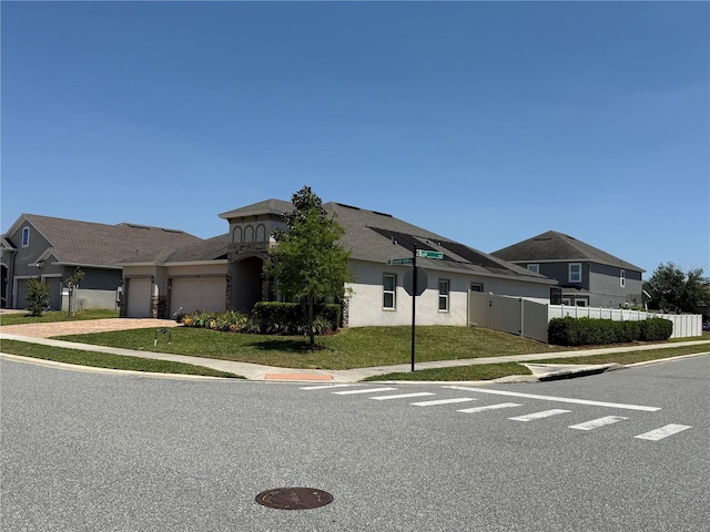 view of front of house featuring fence, driveway, a front yard, and a garage