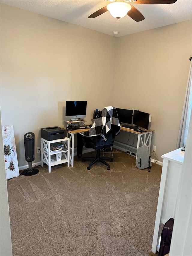 carpeted home office featuring baseboards and a ceiling fan