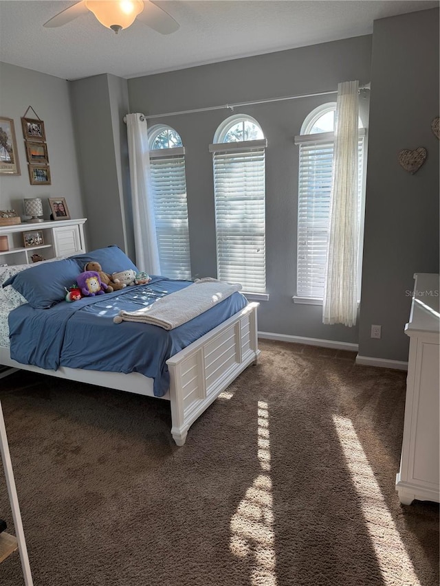 carpeted bedroom with ceiling fan and baseboards