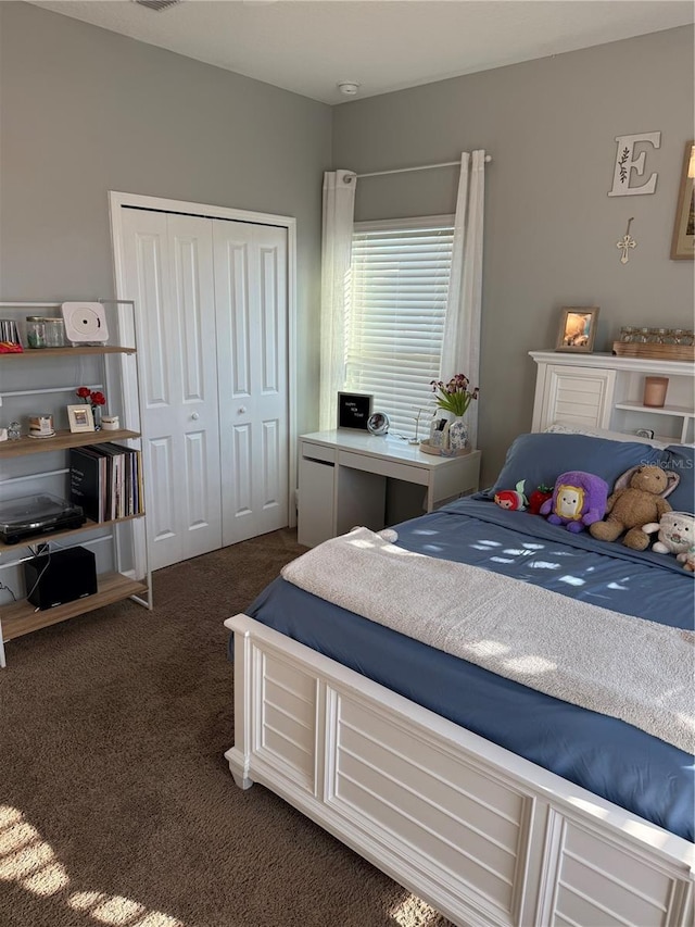 bedroom featuring dark colored carpet and a closet