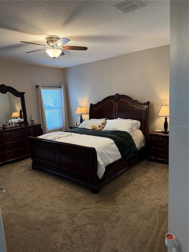 bedroom with visible vents, ceiling fan, a textured ceiling, and light colored carpet