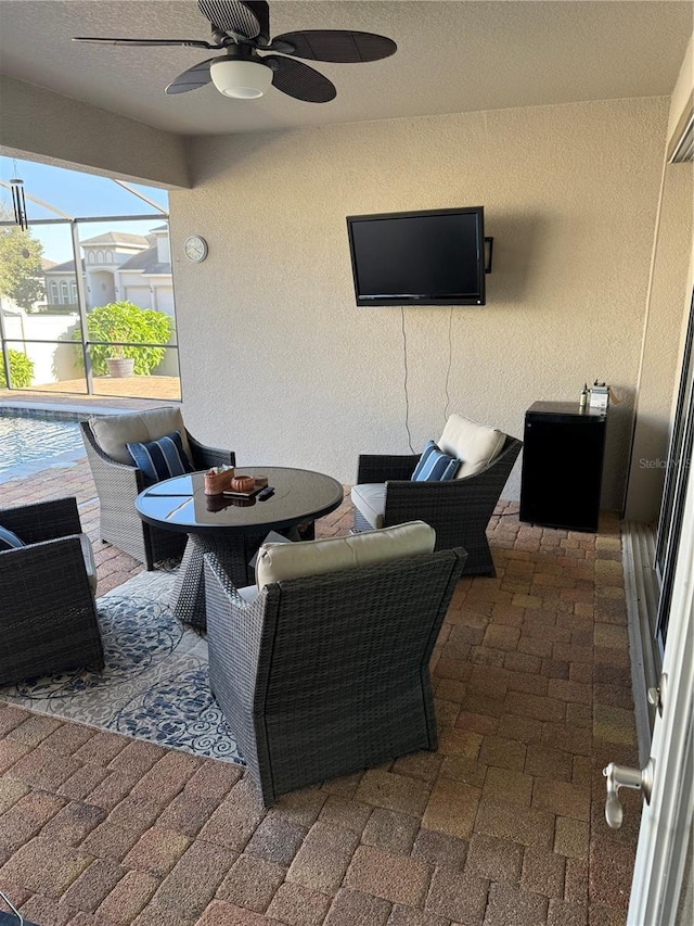view of patio / terrace with a lanai, outdoor dining area, and a ceiling fan