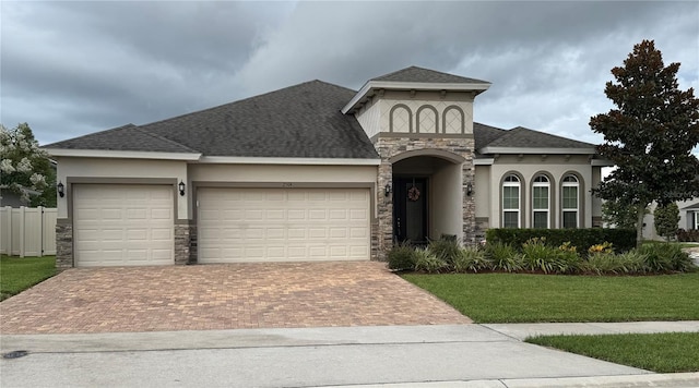 2504 Cavender Creek Rd, Minneola, FL 34715 - view of front of house with stone siding, stucco siding, an attached garage, decorative driveway, and a shingled roof