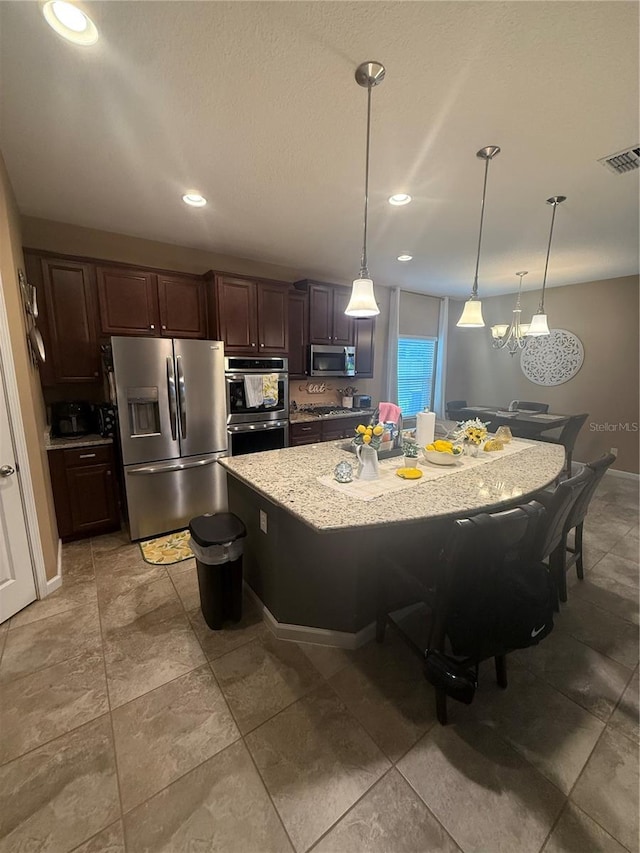 2504 Cavender Creek Rd, Minneola, FL 34715 - kitchen featuring appliances with stainless steel finishes, recessed lighting, a breakfast bar area, pendant lighting, and a spacious island