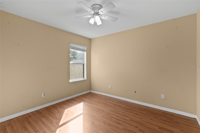 empty room featuring light wood-style floors, a ceiling fan, and baseboards
