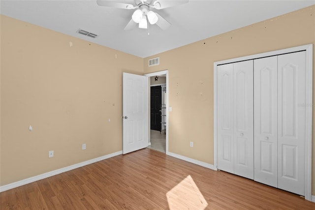 unfurnished bedroom featuring visible vents, a closet, light wood finished floors, and baseboards