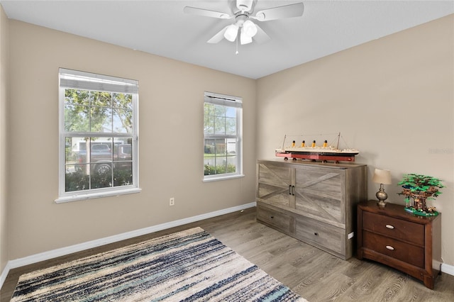 bedroom with wood finished floors, a ceiling fan, and baseboards