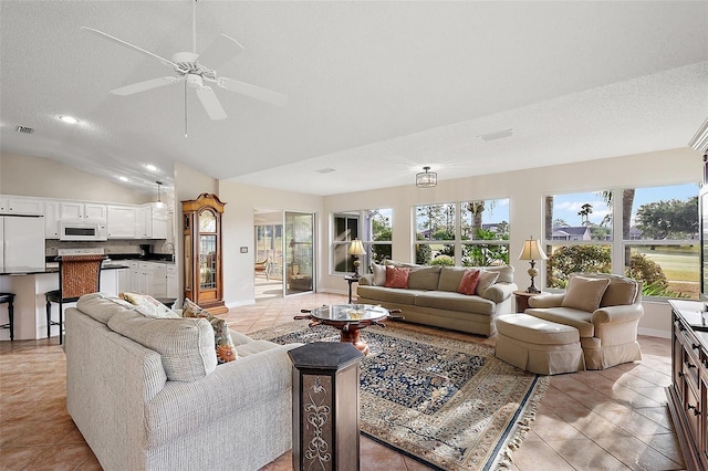 living room with a healthy amount of sunlight, light tile patterned flooring, and vaulted ceiling