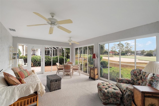 sunroom / solarium with visible vents, a ceiling fan, carpet floors, and an outdoor hangout area