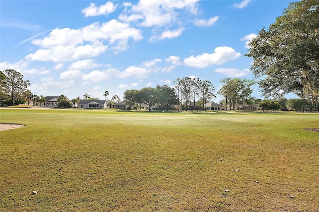 view of property's community featuring a lawn, a residential view, and view of golf course