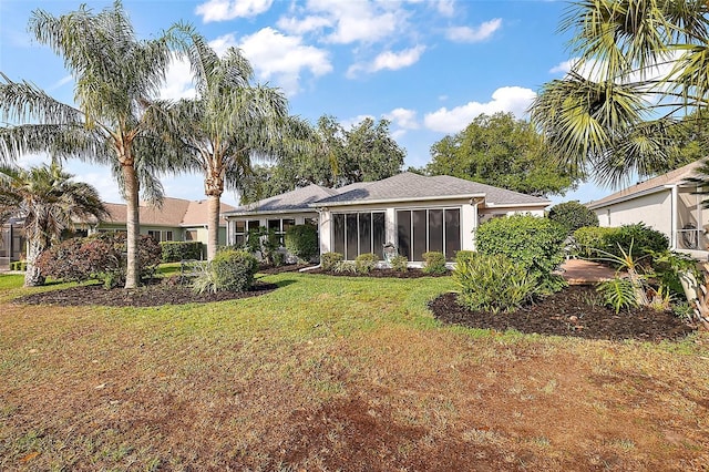 back of house with a sunroom and a lawn