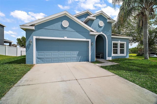 view of front of property with stucco siding, concrete driveway, a front yard, and a garage