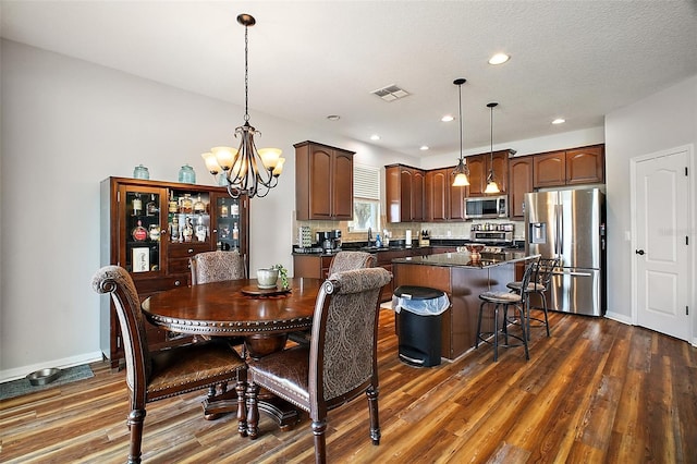 dining room featuring baseboards, visible vents, an inviting chandelier, and dark wood-type flooring